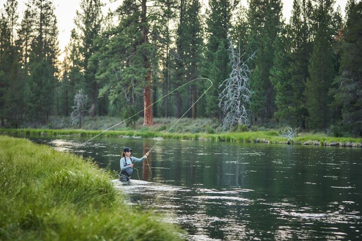 A woman fly fishing on the Deschutes River at La Pine State Park.